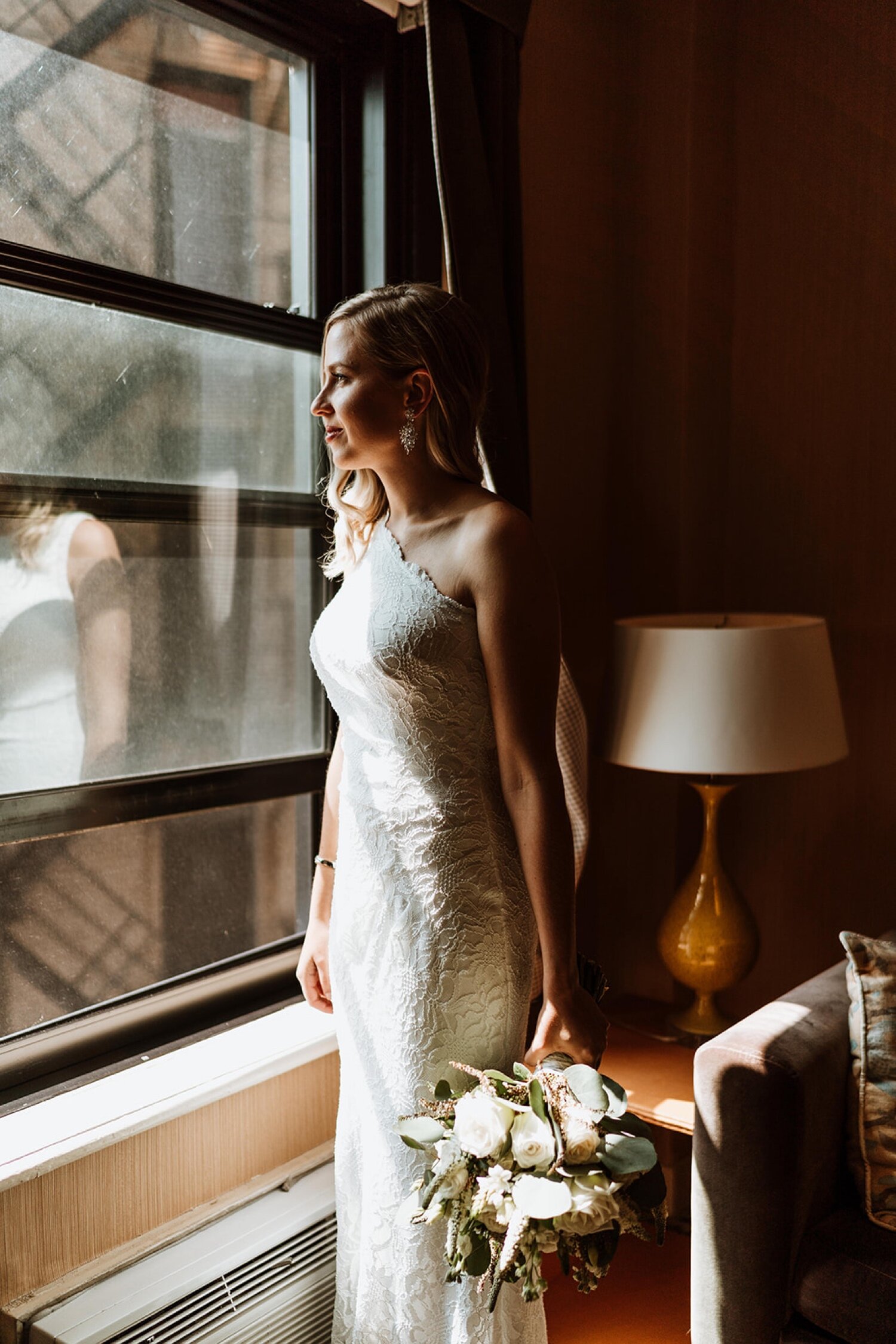 Bride looks out the window the morning of her wedding
