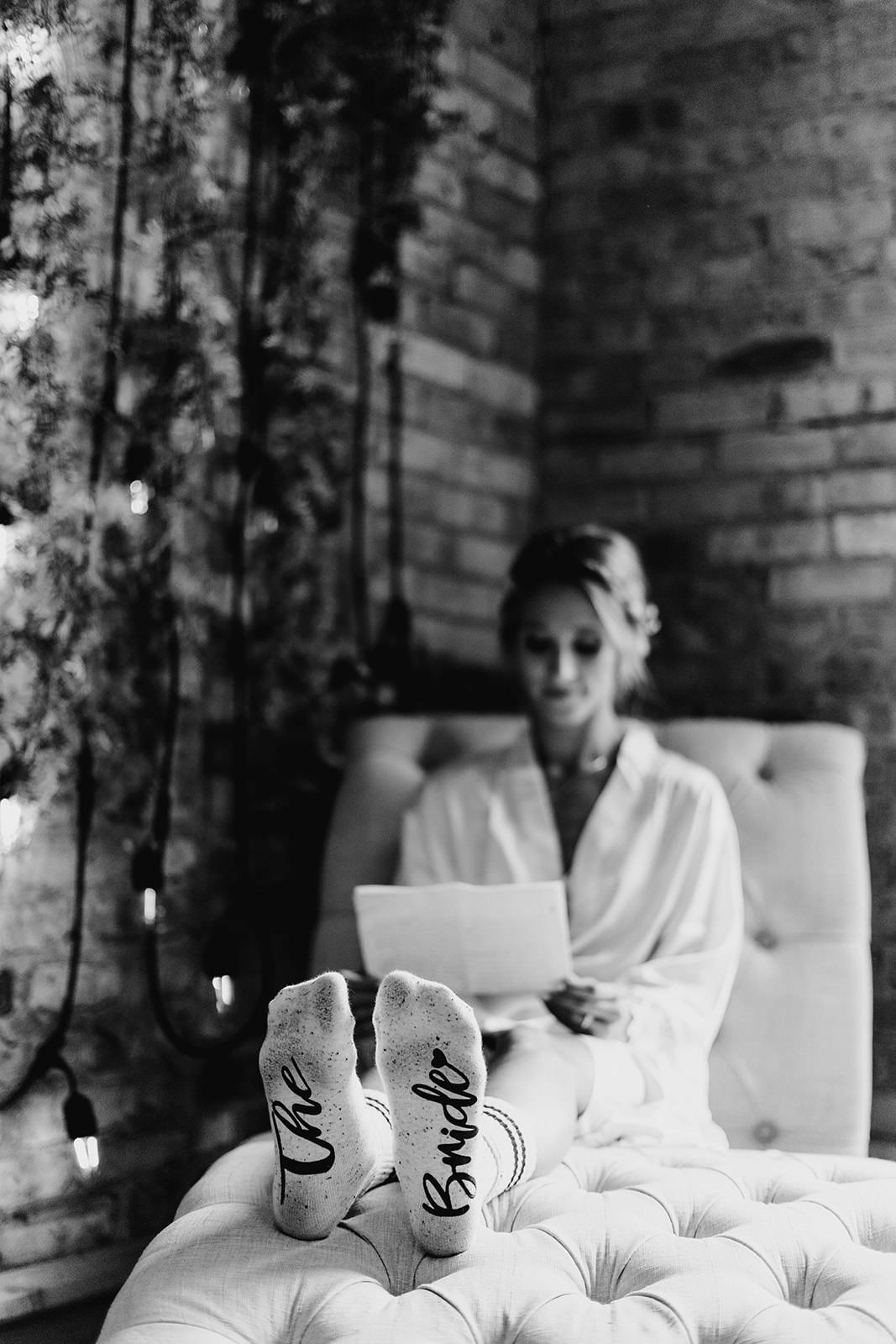 Bride reads a note with her wedding day socks on