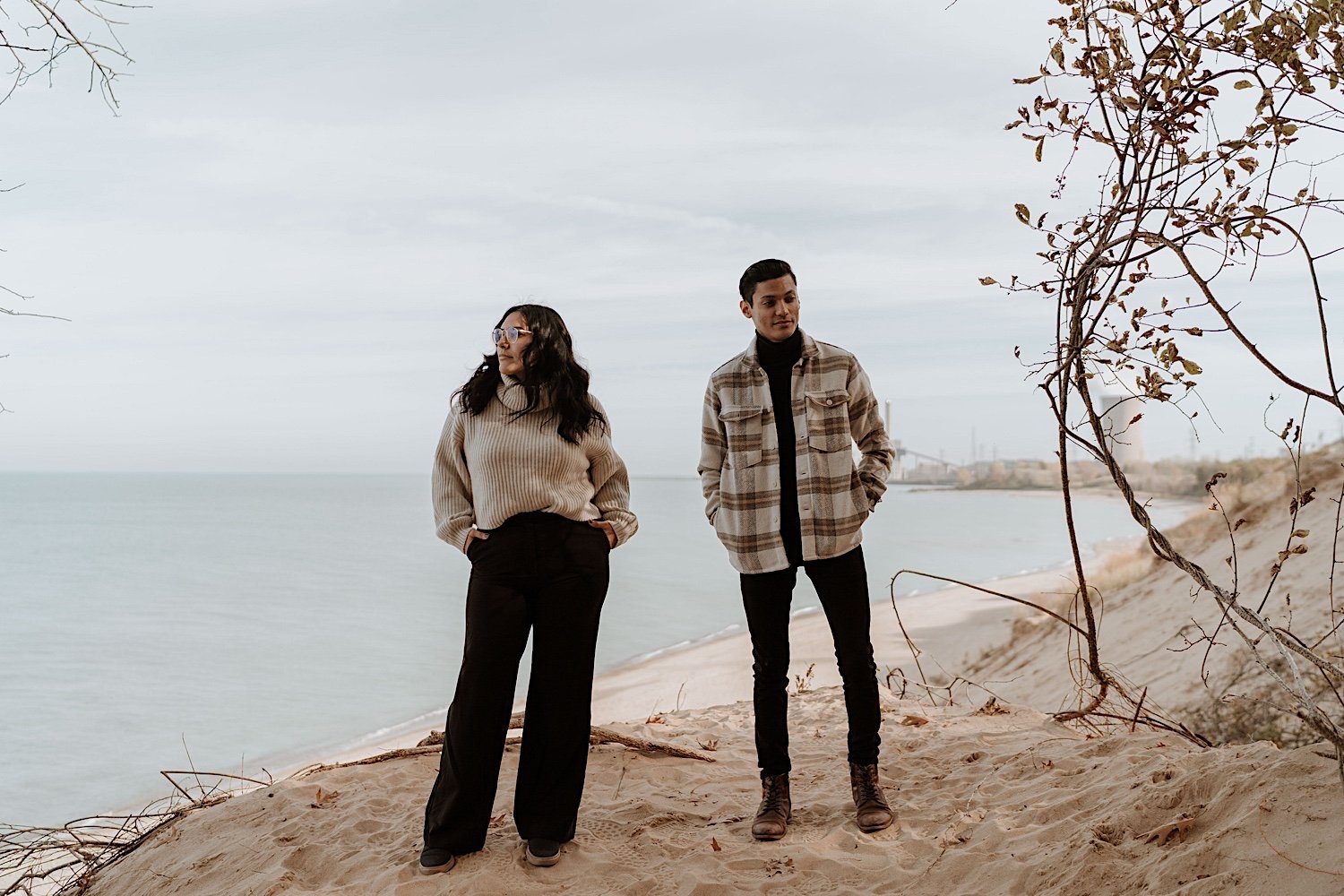 Couple poses in front of beach for anniversary session at Indiana Dunes