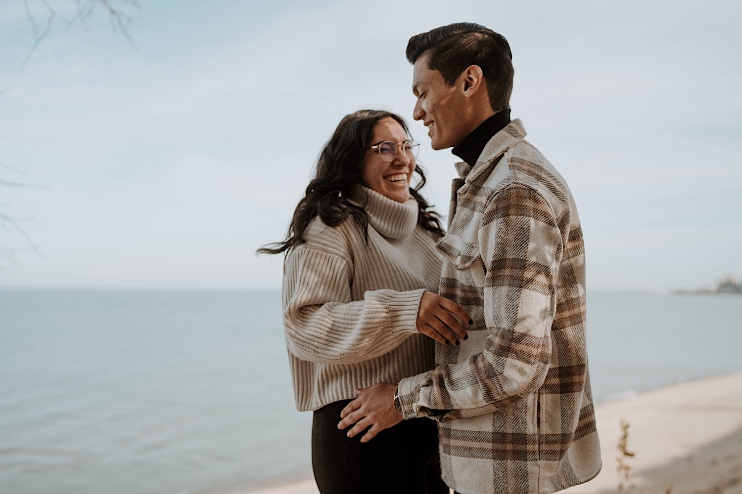 Couple laugh at the beach for anniversary session at Indiana Dunes