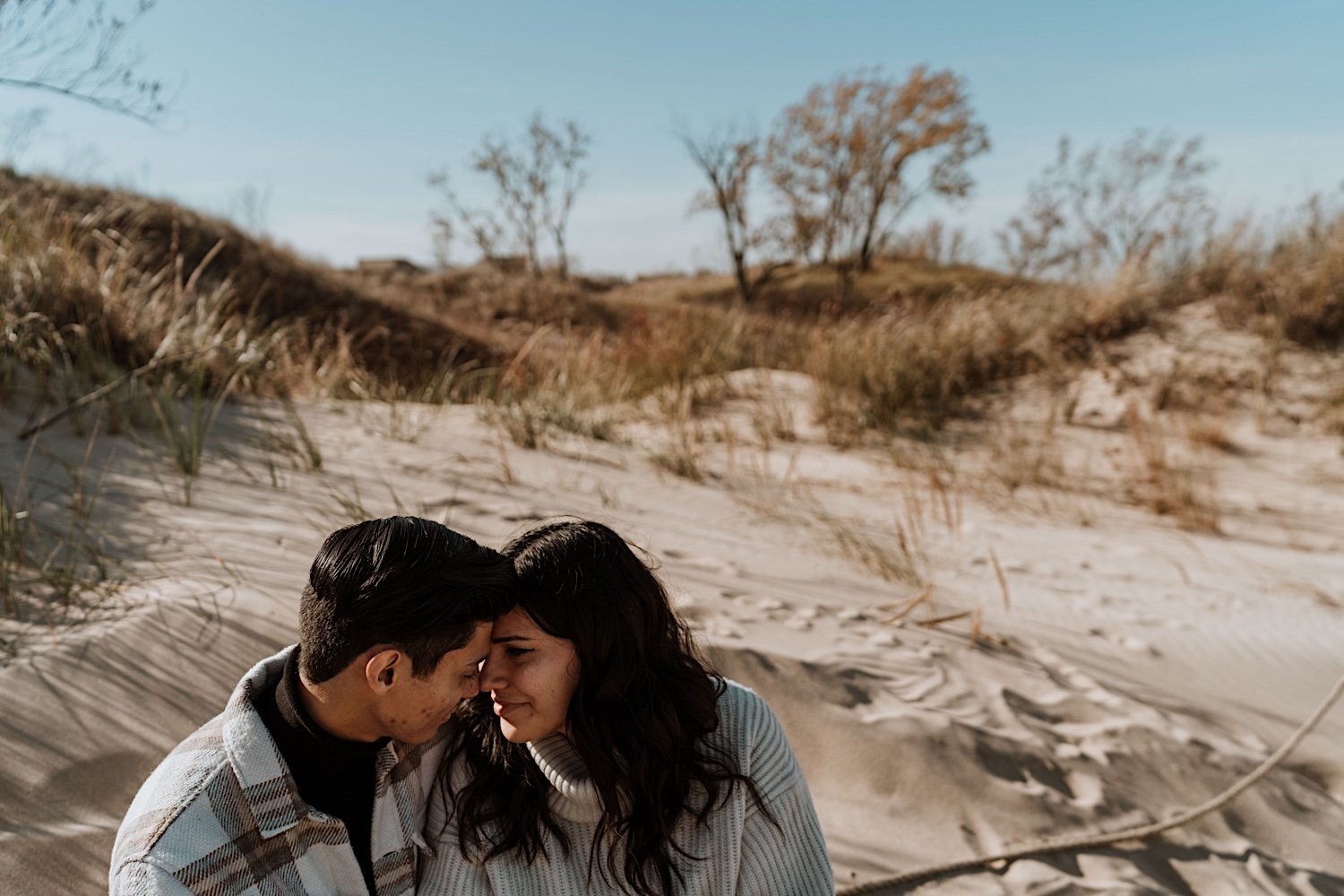 Couple cuddle at Indiana Dunes for anniversary session
