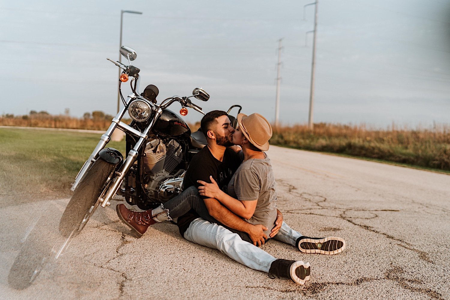 Couple kiss next to motorcycle before surprise proposal