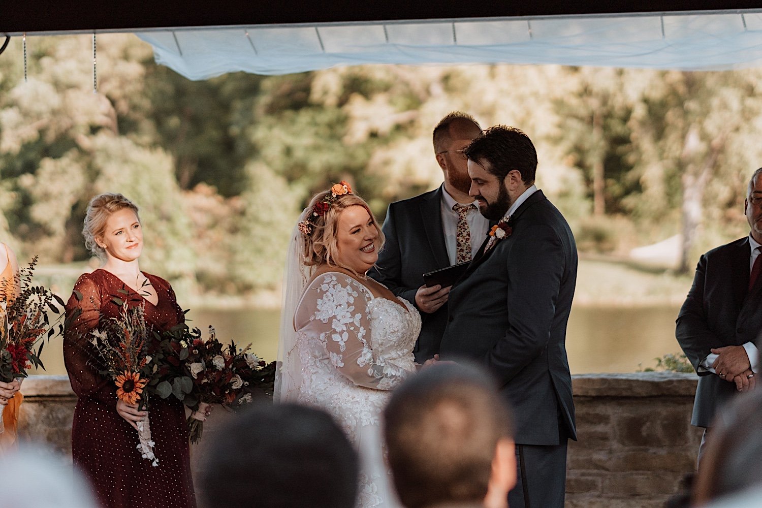 Bride and groom smiling during their Lake Ellyn Boathouse wedding ceremony