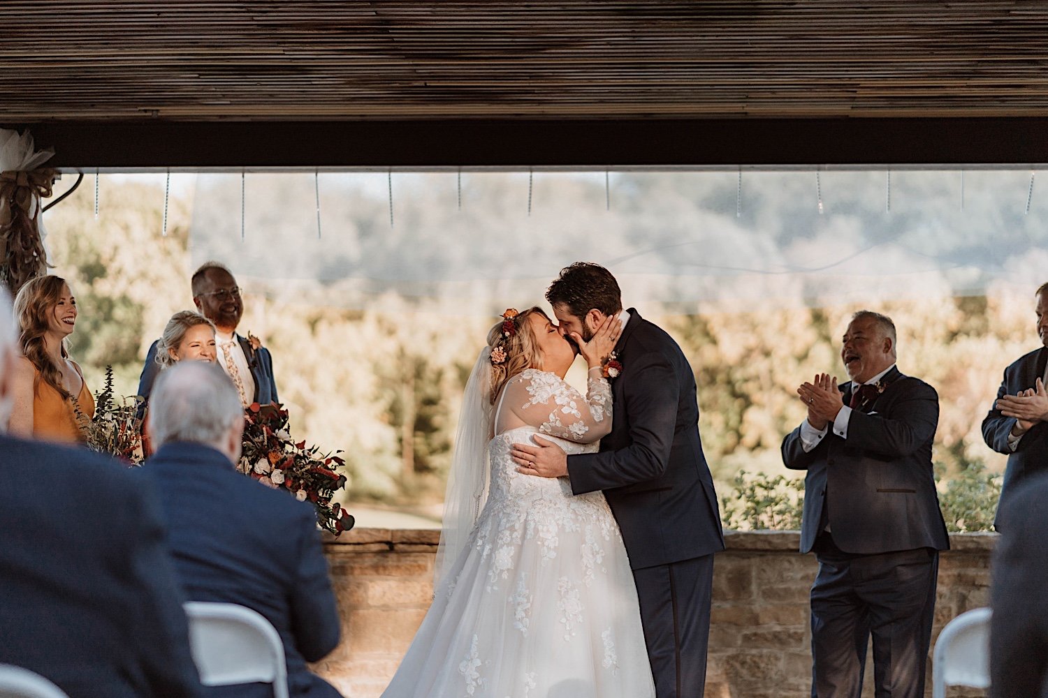 Bride and groom share first kiss at Lake Ellyn Boathouse wedding ceremony