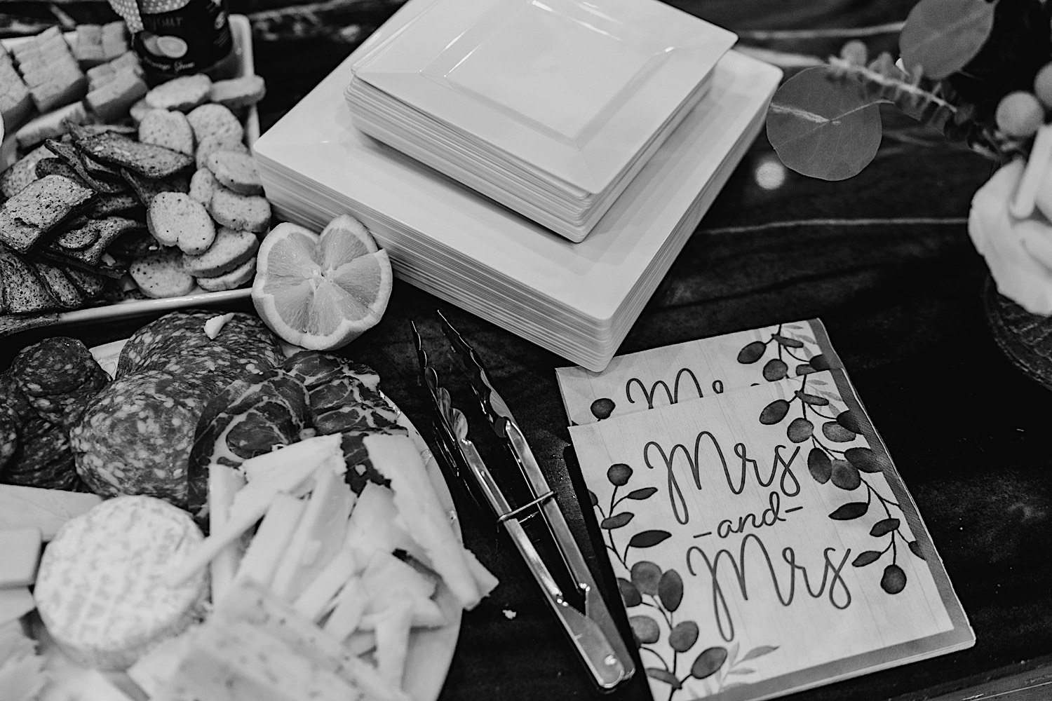 Black and white picture of snacks, tongs, plates and wedding cards