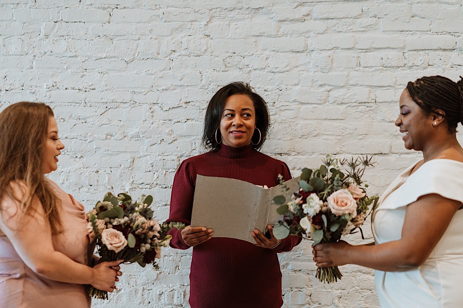Brides holding flowers as they are married