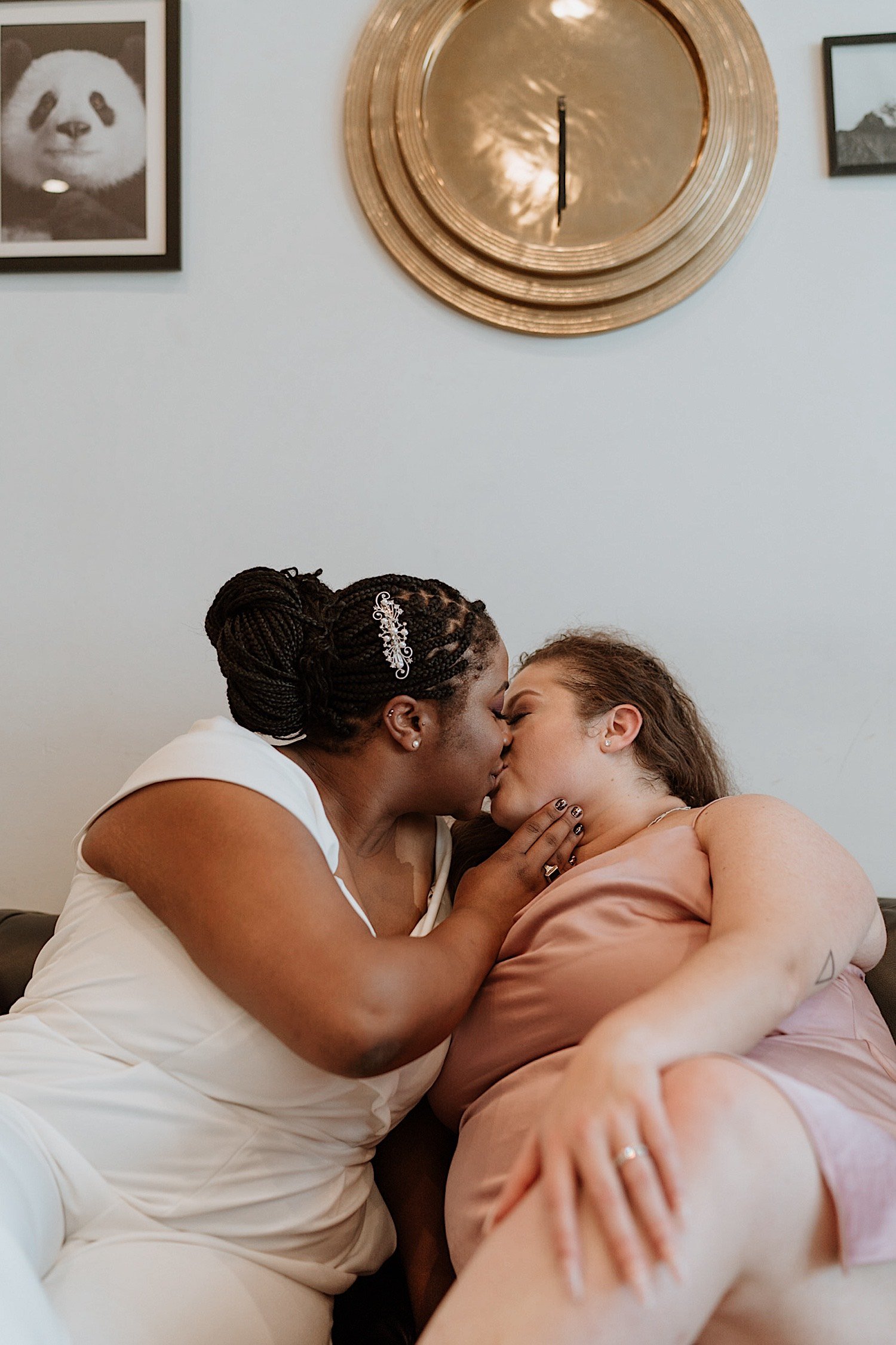 Brides kiss on the couch after their wedding