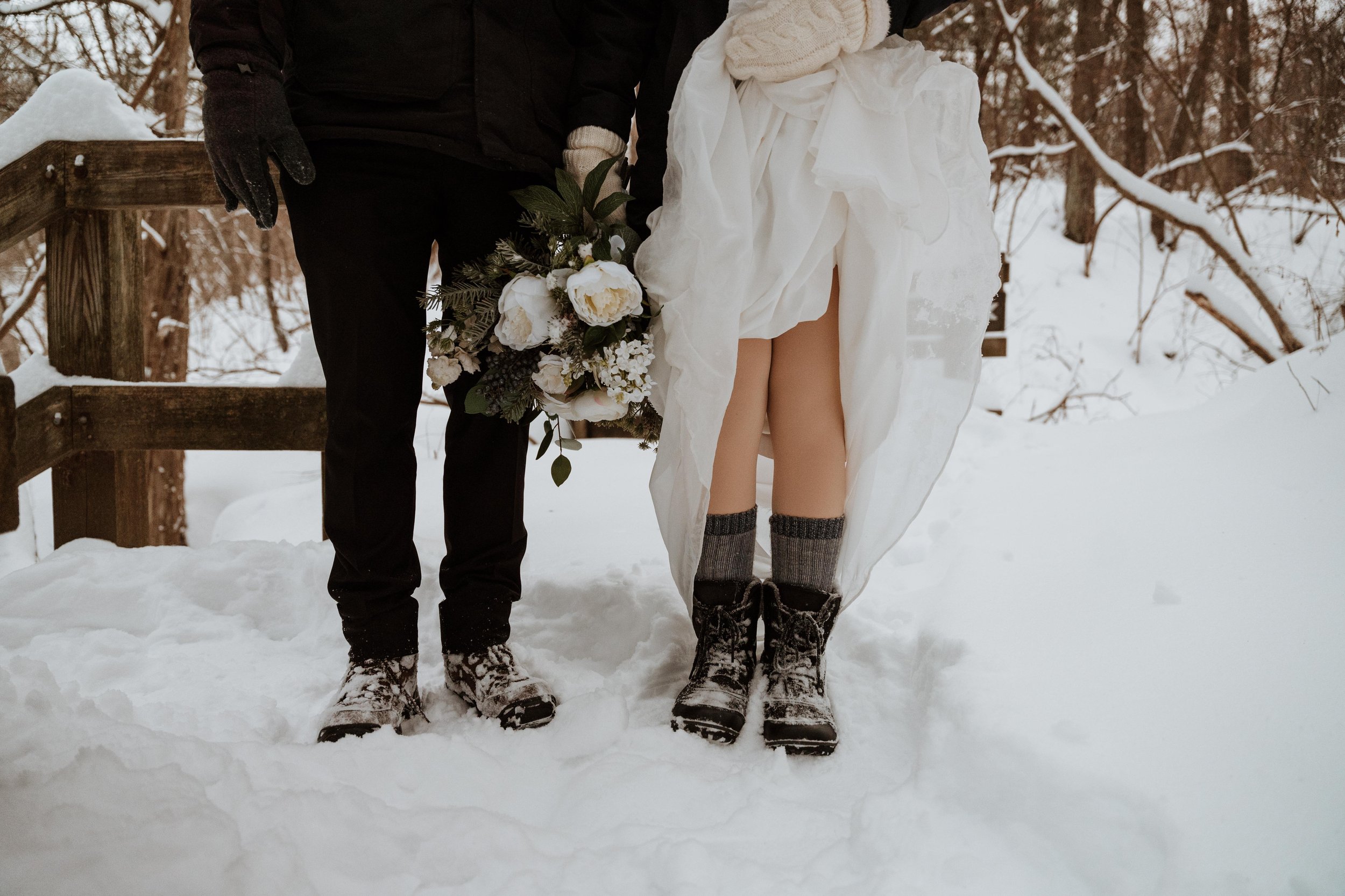 Bride and groom show off their winter boots after their wedding