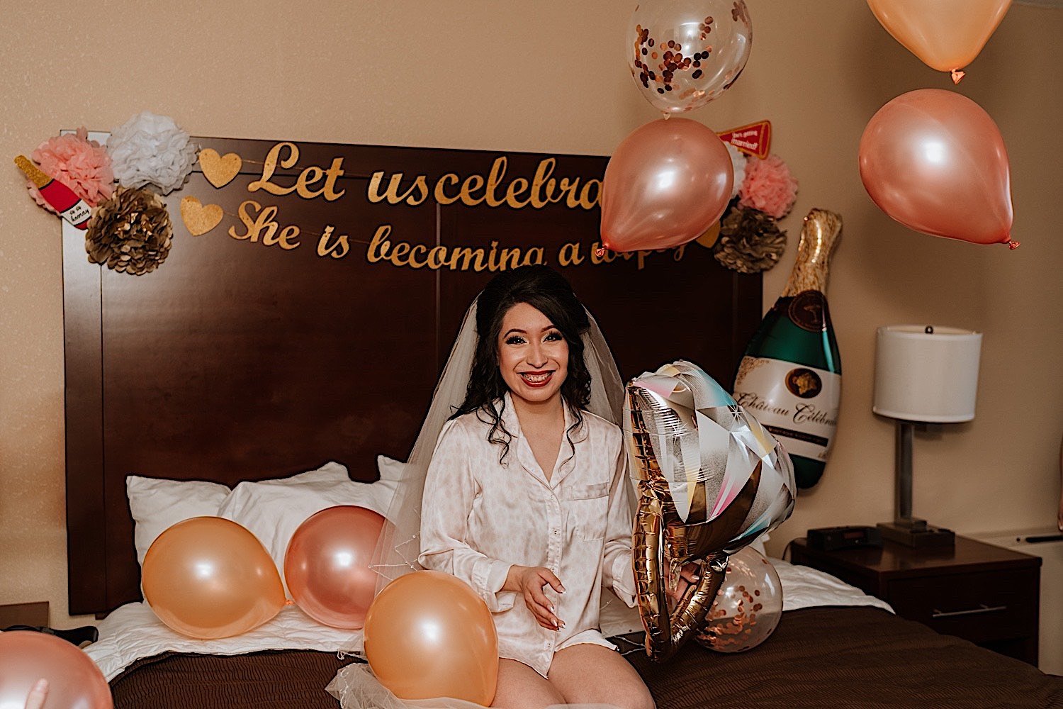 Bride sits in bed with blowup balloons before getting ready for her wedding