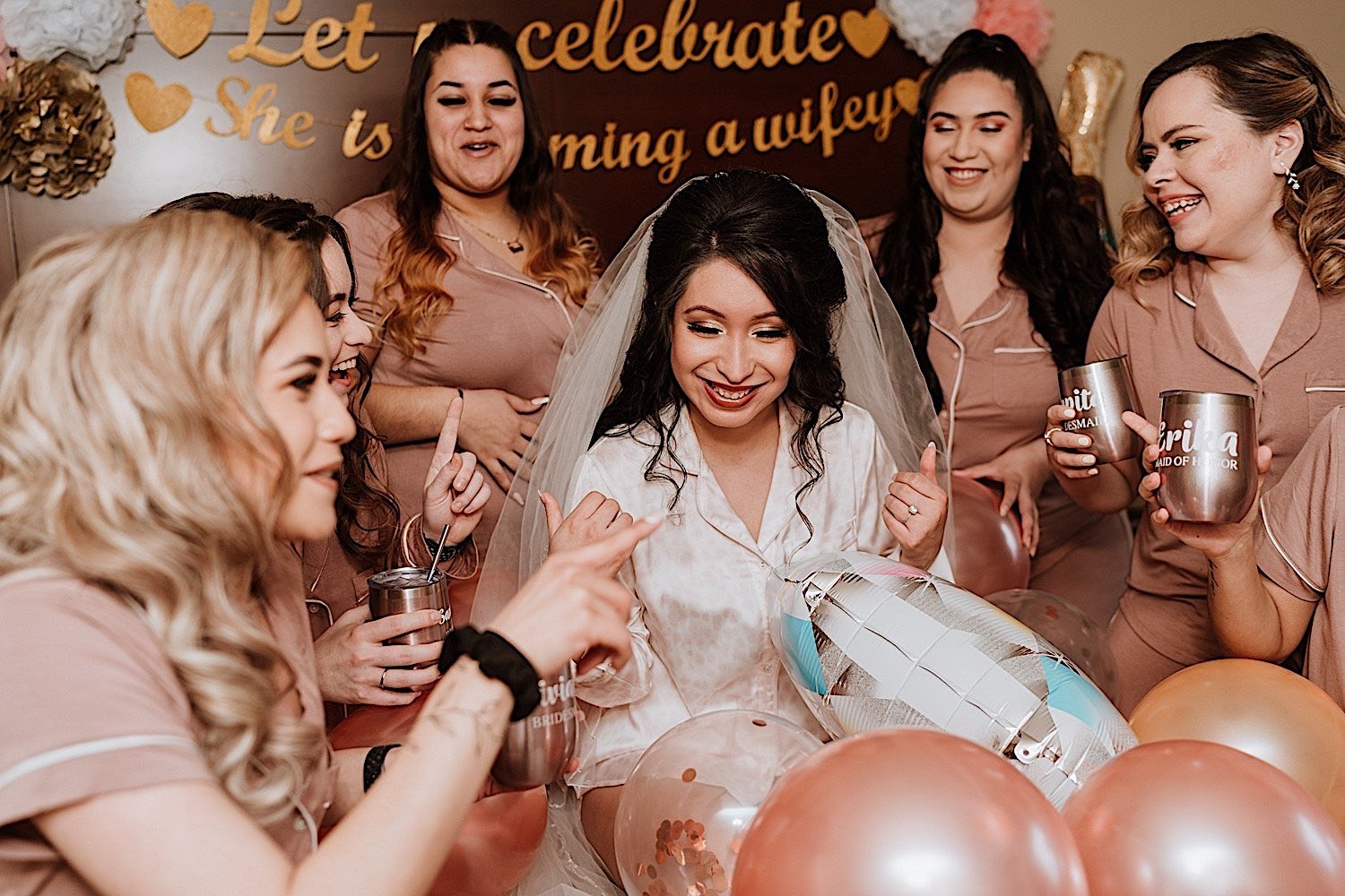 Bride shares drinks in bed with bridesmaids before wedding