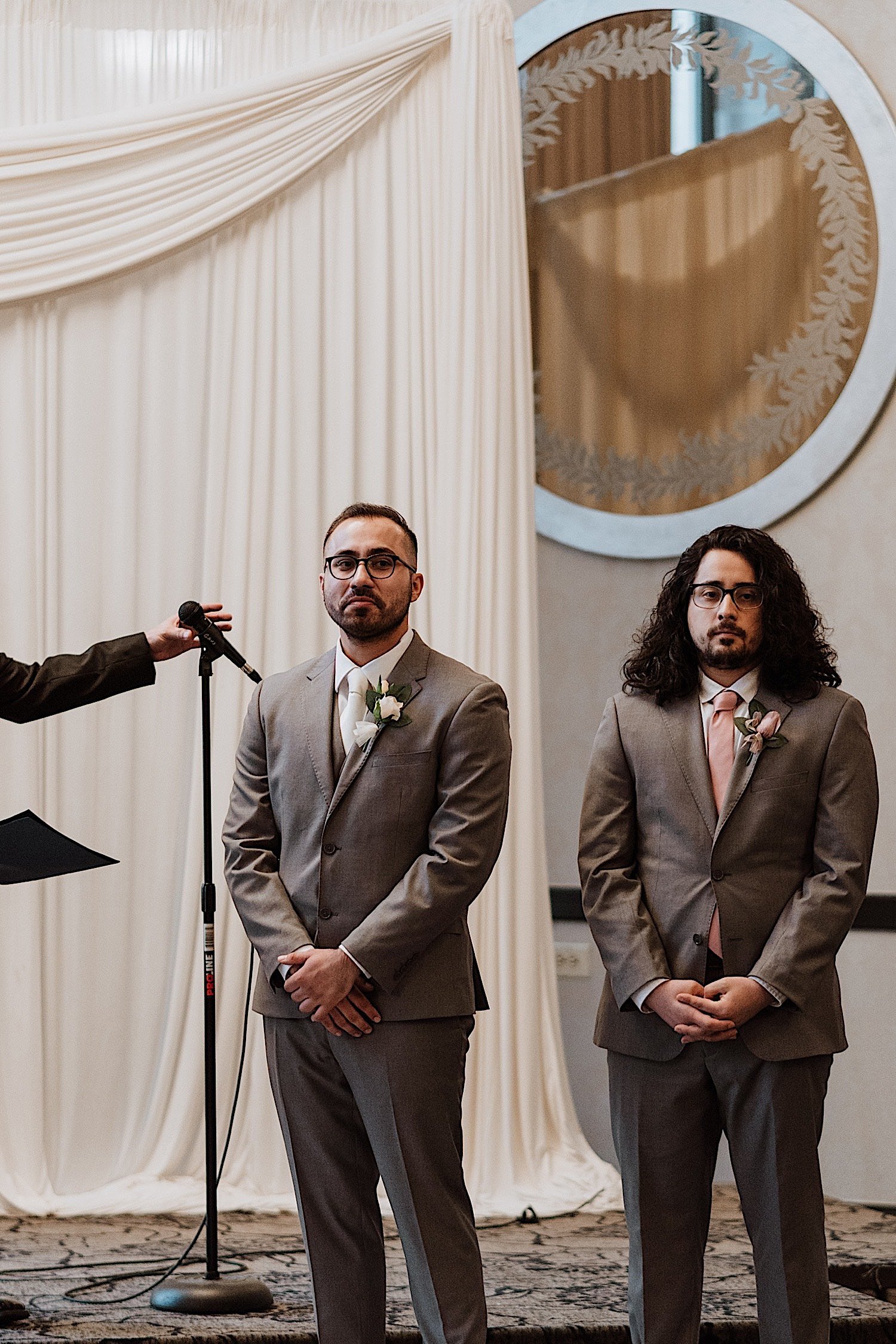 Groom starts to tear up as he sees his bride enter the ceremony space while standing next to his best man