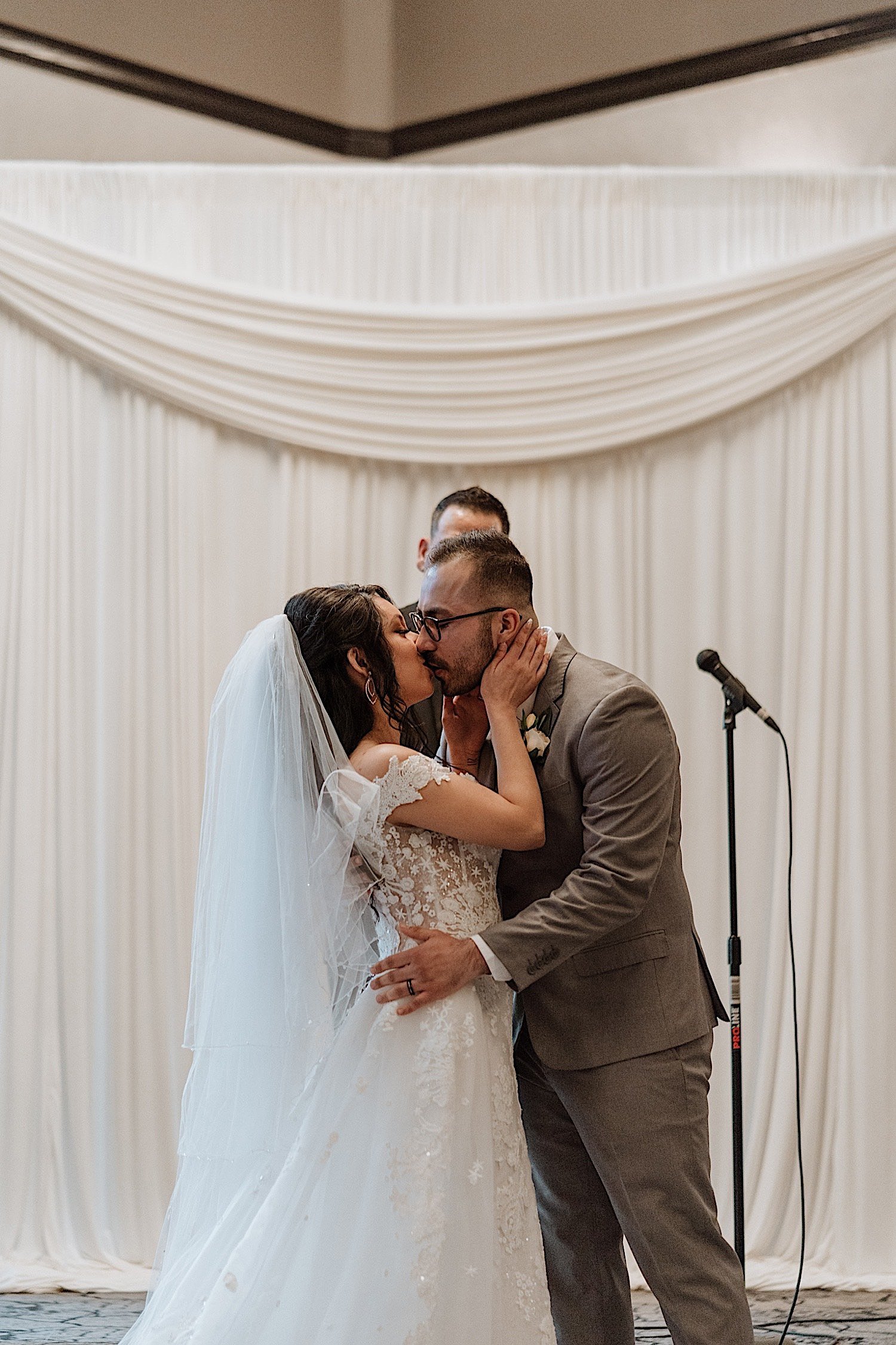 Bride and groom share first kiss during wedding ceremony