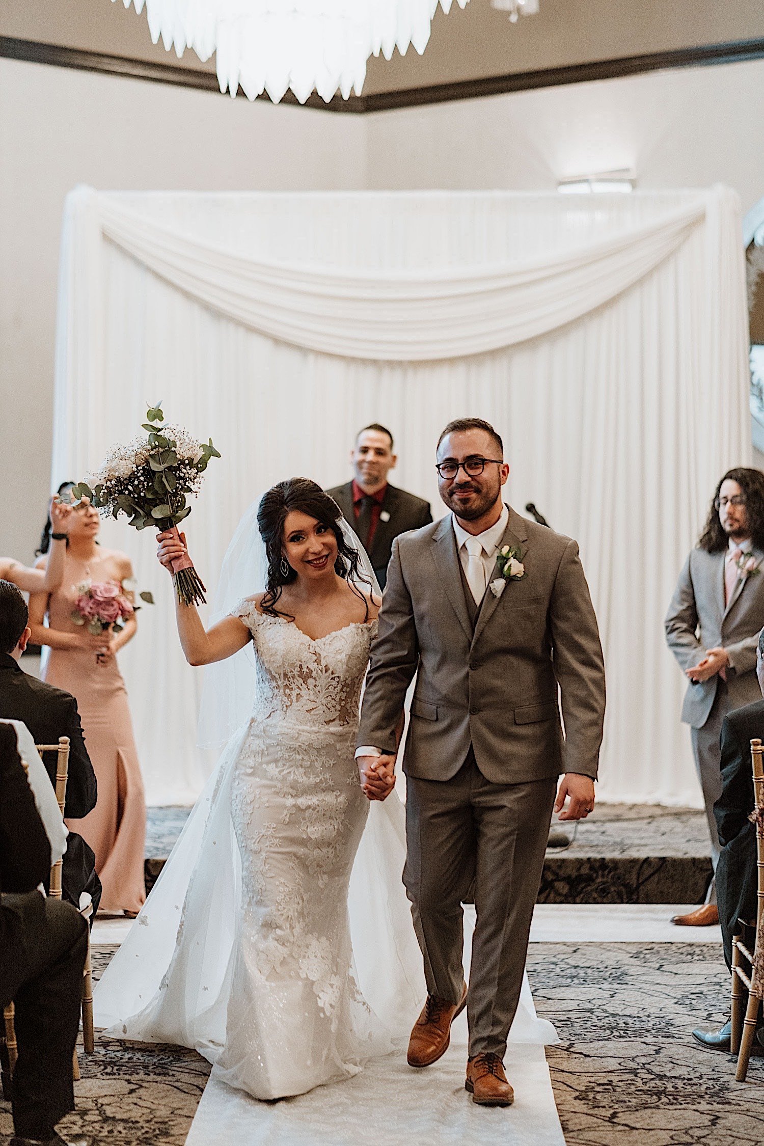 Bride and groom walk down the aisle of their Chicagoland ballroom wedding after officially being married