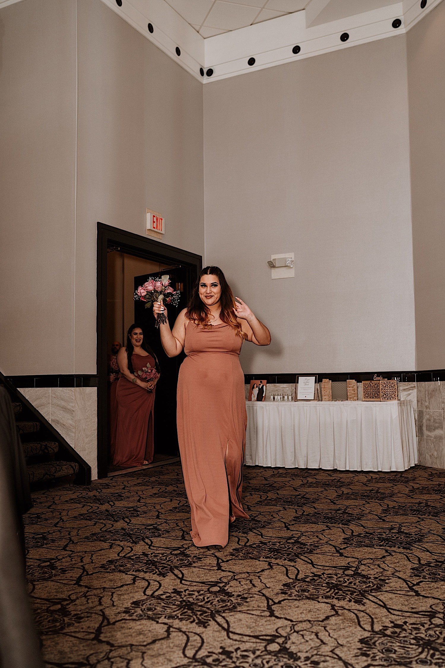 Bridesmaids enter the ballroom for the wedding reception holding bouquets