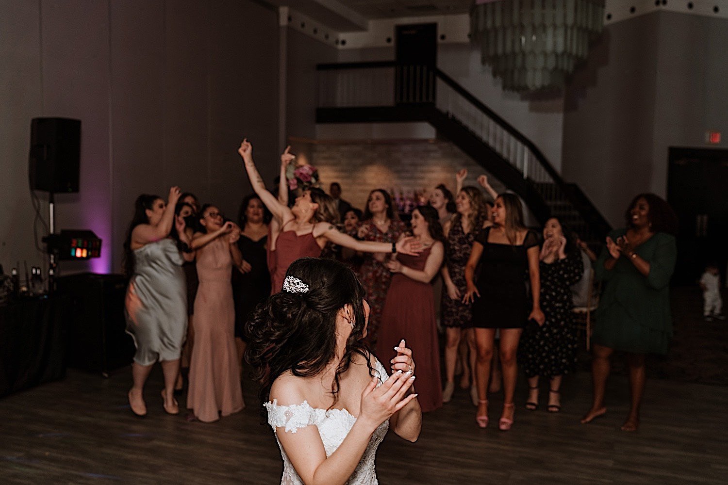 Bride tosses the bouquet to guests standing behind her during Chicagoland ballroom wedding reception