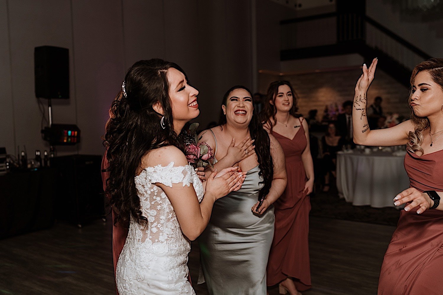Bride and guests smile and laugh as they dance during Chicagoland ballroom wedding reception