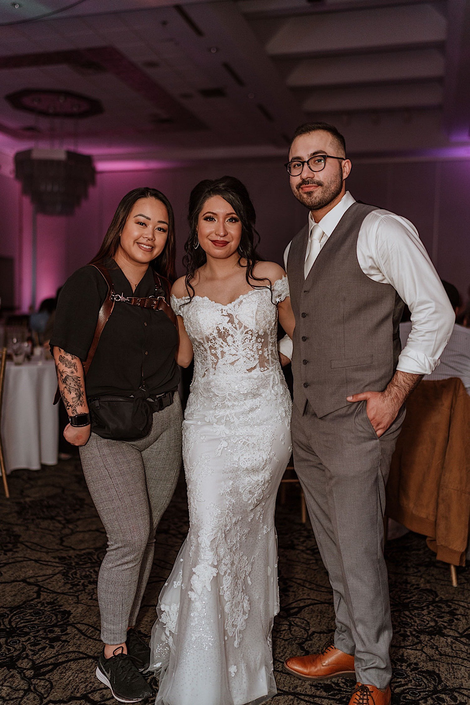 Bride and groom pose with wedding photographer after their Chicagoland ballroom wedding