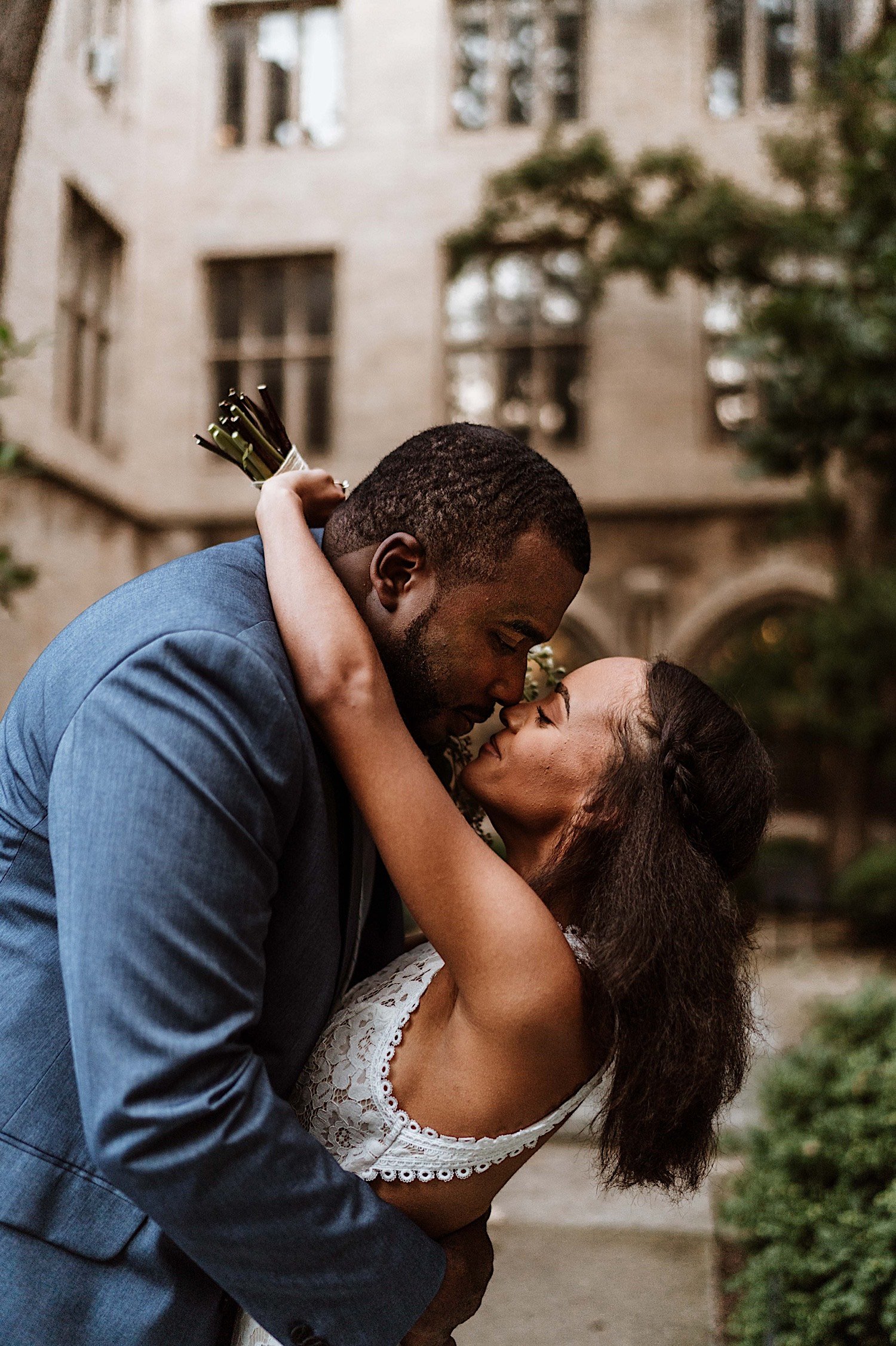 Bride and groom hold one another about to kiss in University of Chicago campus