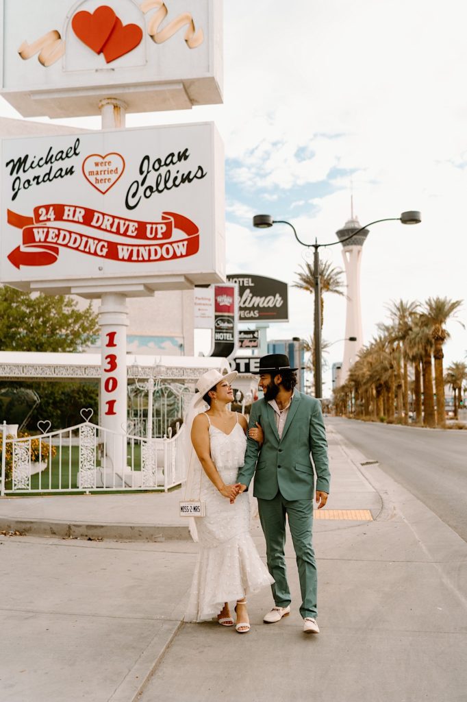 A bride and groom walk towards the White Little Chapel in Las Vegas Nevada.