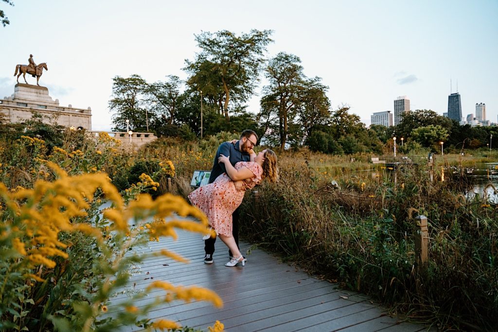 A groom dips his bride after proposing at the Lincoln Park Boardwalks.