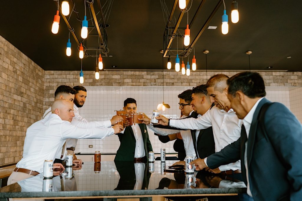 The groom shares a toast with his groomsmen and family the morning of his wedding day at his Chicago airbnb.