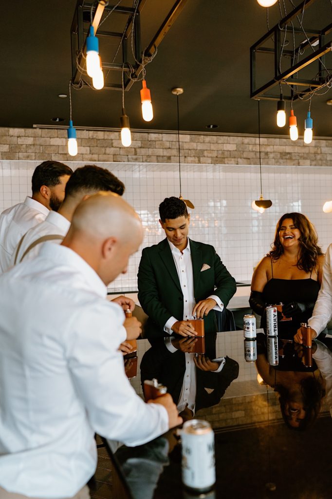 The groom shares a drink with his groomsmen and family the morning of his wedding day at his Chicago airbnb.