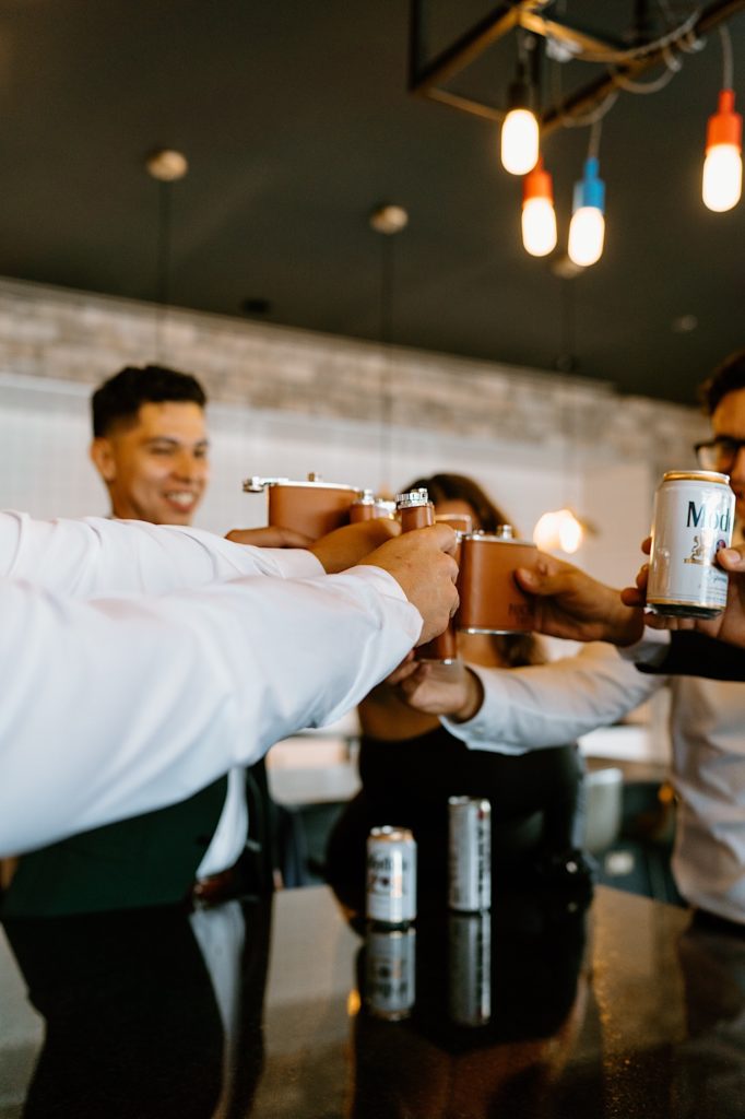 The groom shares a drink with his groomsmen and family the morning of his wedding day at his Chicago airbnb.