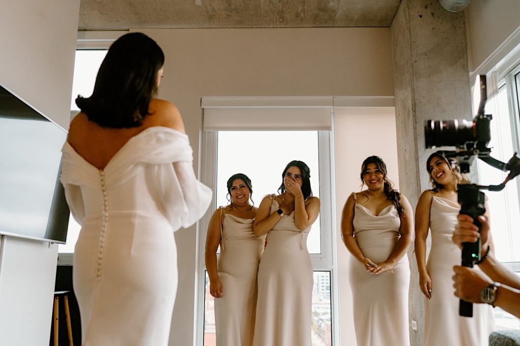 A bride has a first look with her bridesmaids in their Chicago Airbnb.