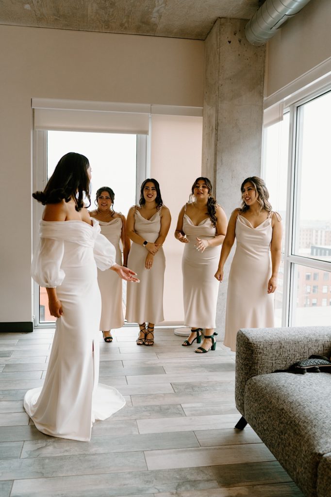 A bride has a first look with her bridesmaids in their Chicago Airbnb.