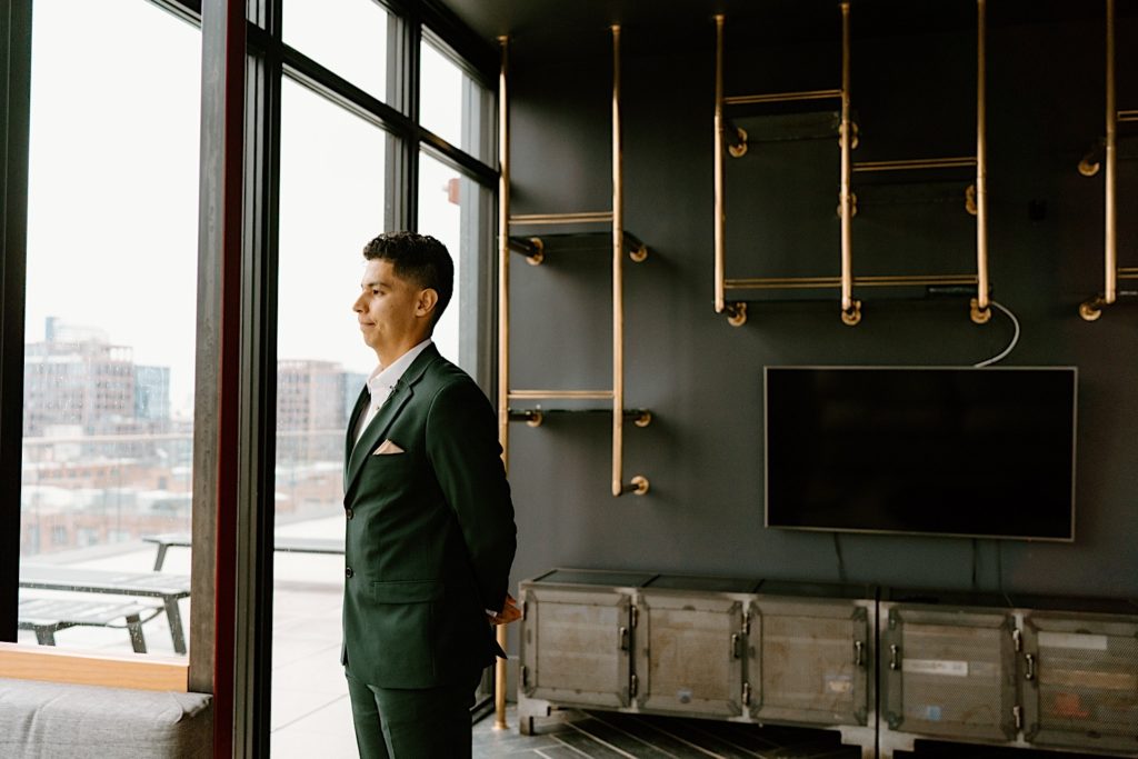 A groom stands and waits for his bride for their first look at their Chicago Airbnb.
