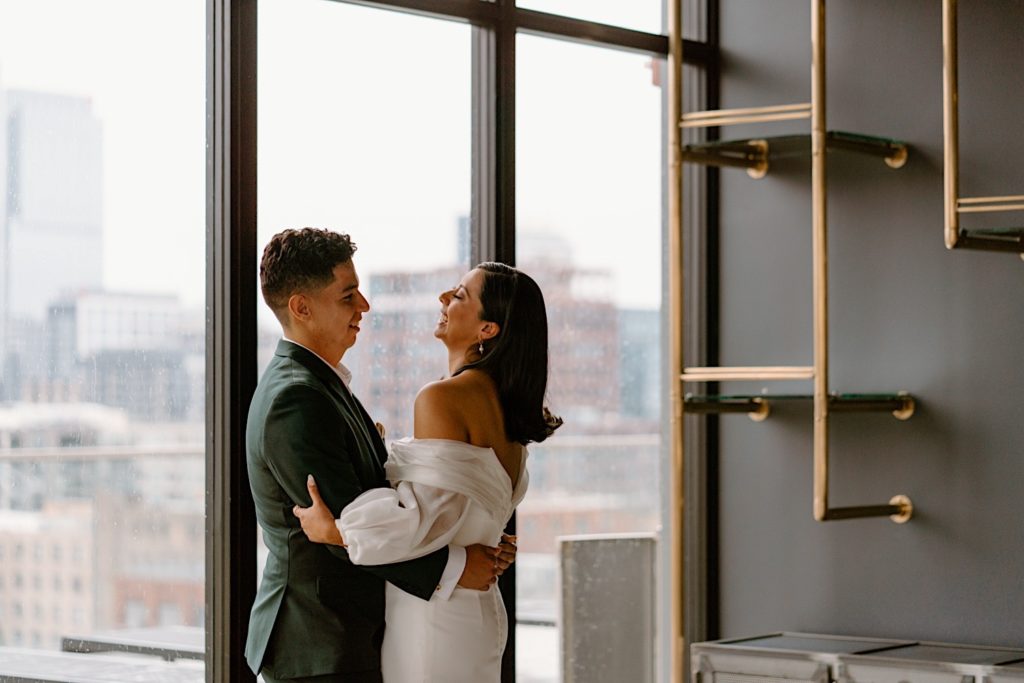 A bride and groom see one another for the first time the morning of their wedding during their first look at a Chicago Airbnb.