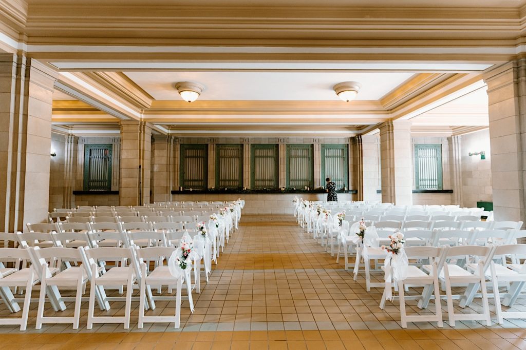 The ceremony space in Joliet Union Station with white chairs and light colored flowers.