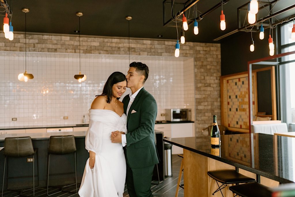 A bride and groom pop champagne to celebrate their wedding day in their Chicago Airbnb.