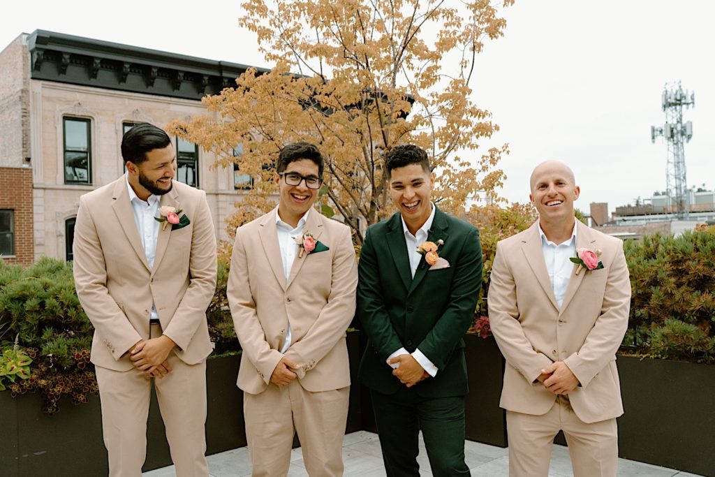 The groom and his wedding party posing for portraits on a Chicago rooftop.