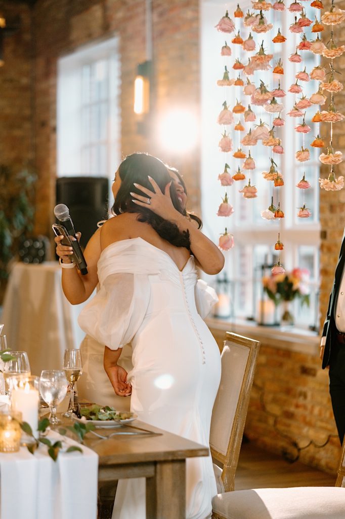 The bride hugs a bridesmaid after her speech at their intimate wedding in Chicago