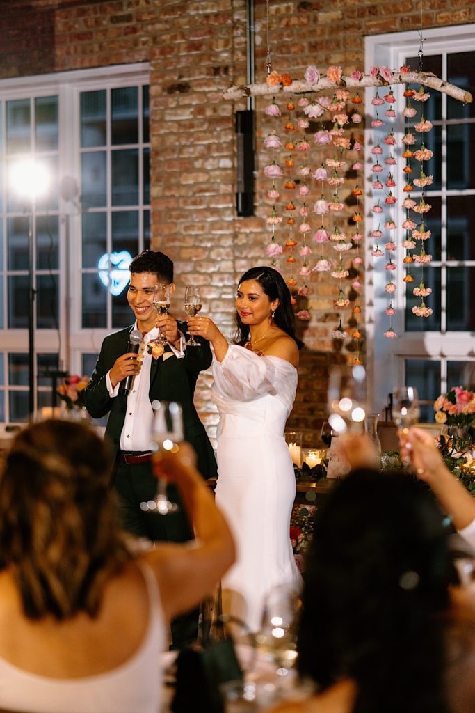 The bride and groom propose a toast to their loved ones and guests at their wedding at Loft Lucia.