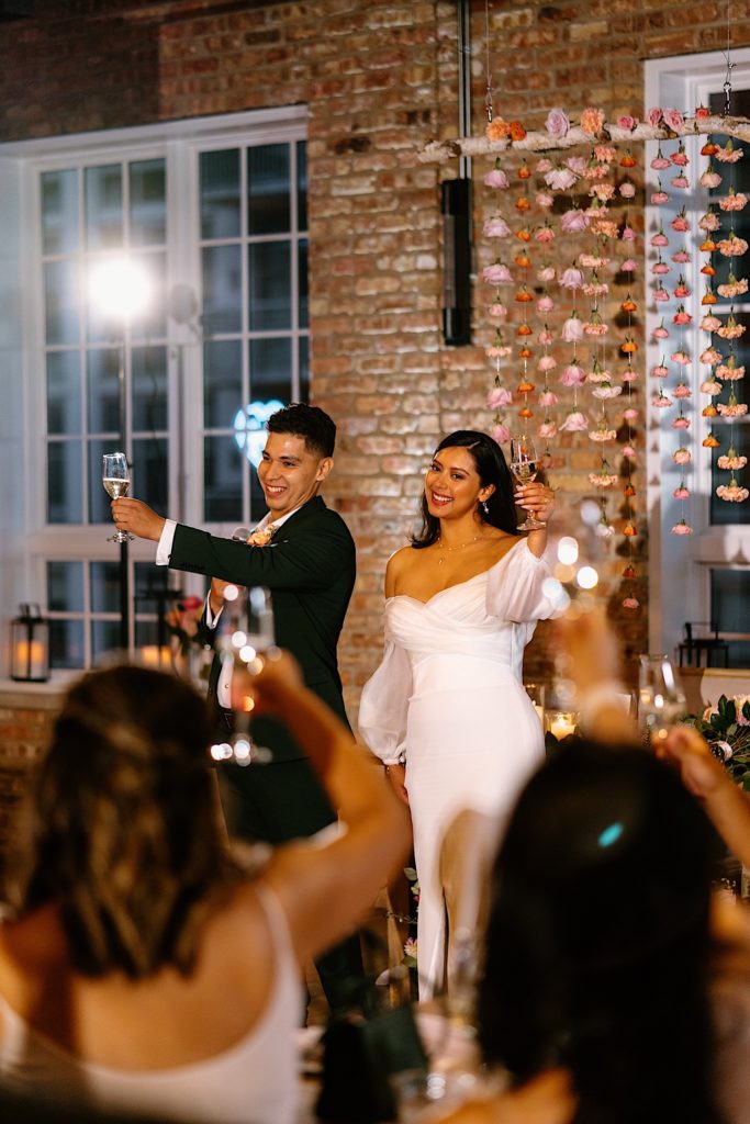 The bride and groom propose a toast to their loved ones and guests at their wedding at Loft Lucia.