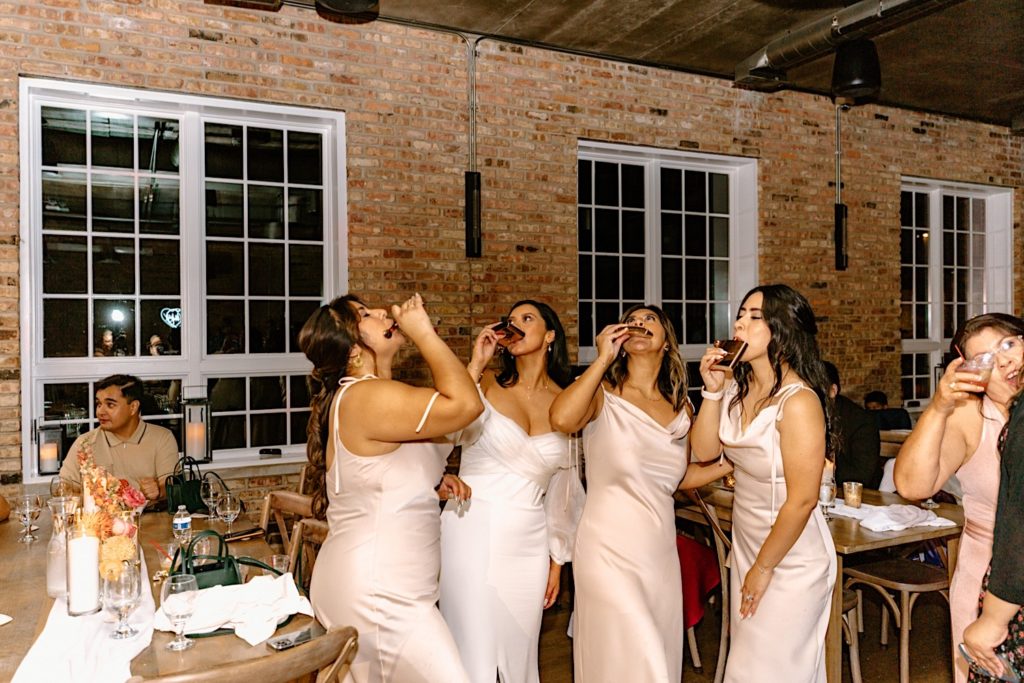 The bride and their bridesmaids take a shot together at their Chicago wedding reception