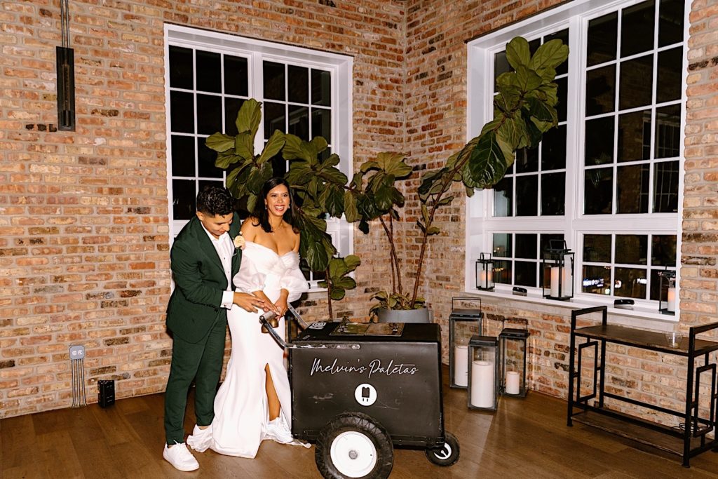 The bride and groom bring out a Wedding Paleta Cart at their Chicago wedding