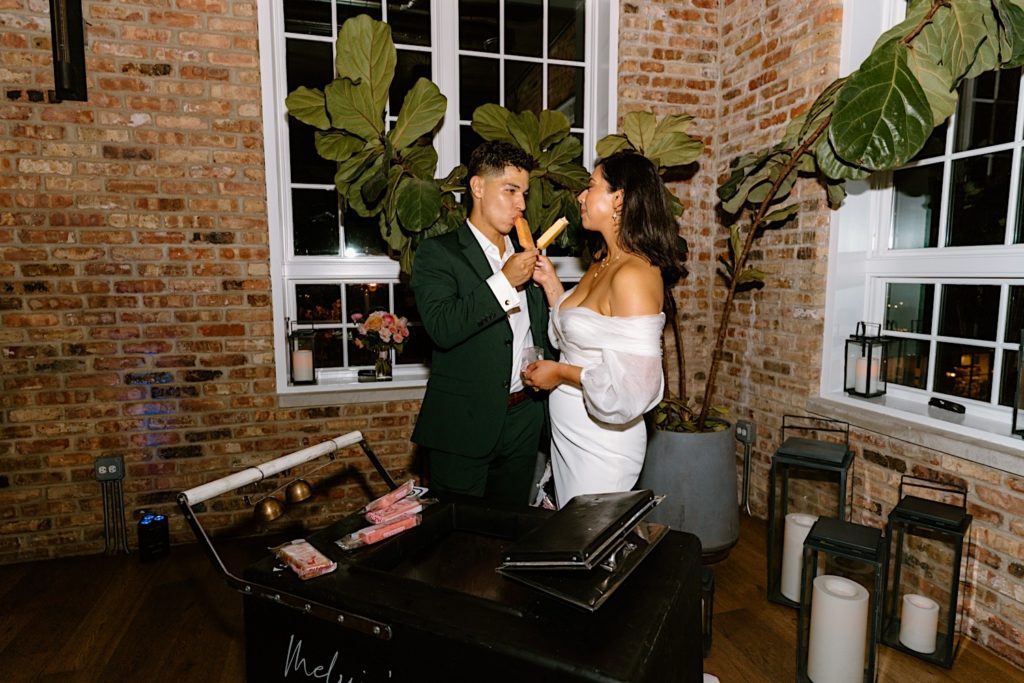 The bride and groom bring out a Wedding Paleta Cart at their Chicago wedding and eat two together
