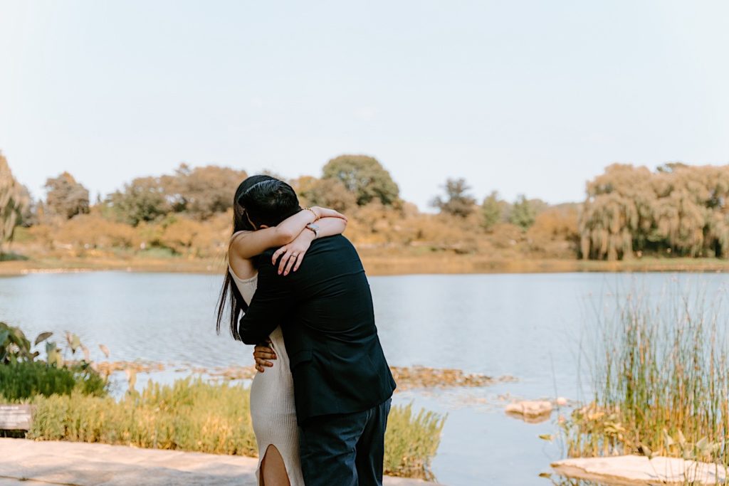 Fiancés hug while holding one another at the Chicago Botanic Gardens
