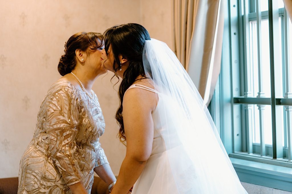 A bride kissing her mother on the cheek prior to her wedding ceremony at Joliet's Union Station.