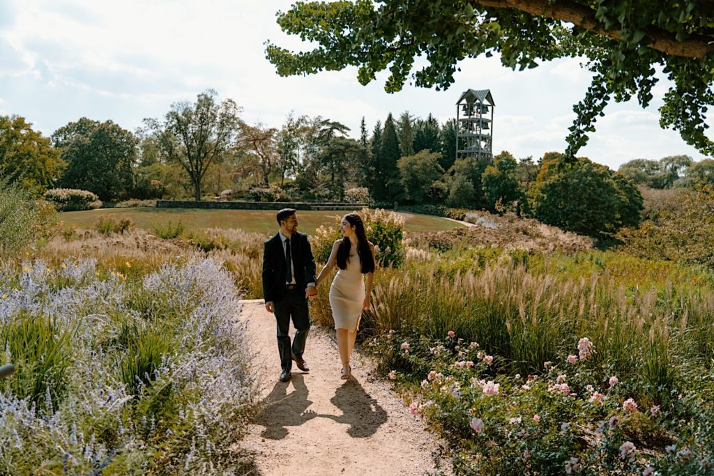 A couple walks towards the camera surrounded by prairie and flowers at the Chicago Botanic Gardens.