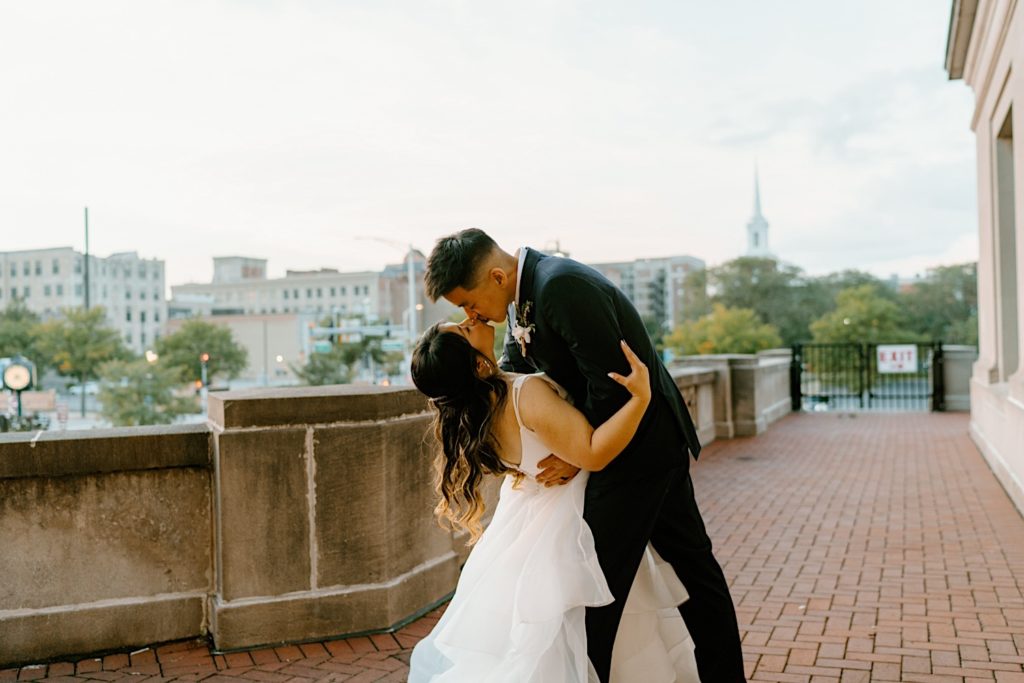 A bride and groom dance while kissing on the balcony at Joliet Union Station. 