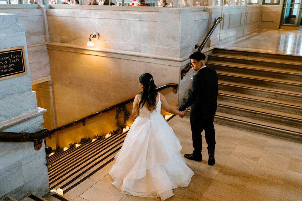 A bride and groom get ready to walk down the stairs at Joliet Union Station to take more portraits outside. 