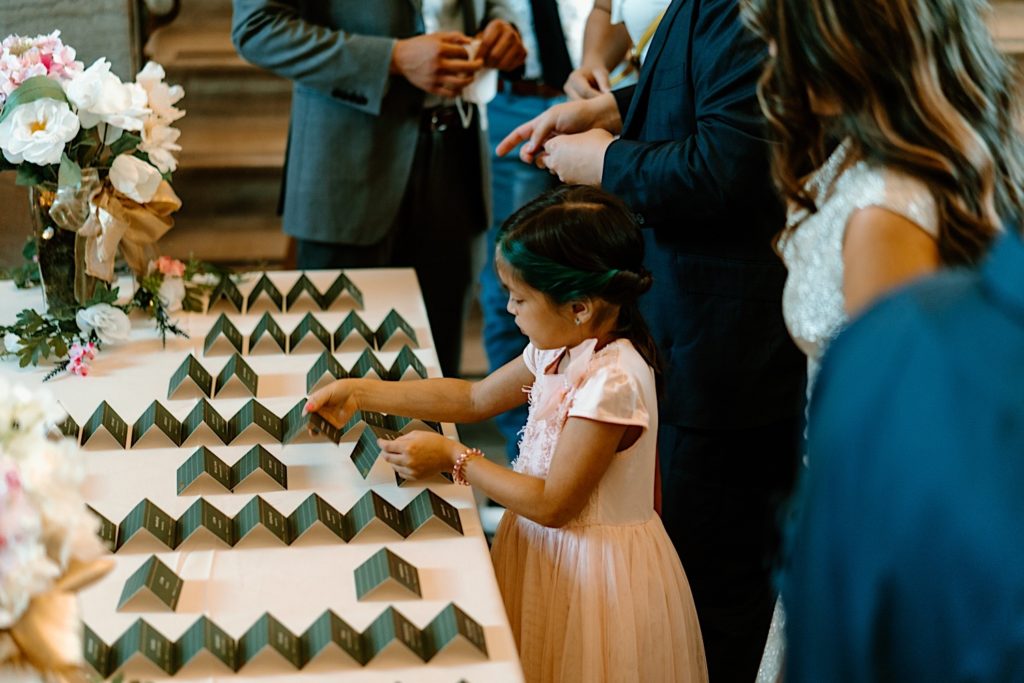 A flower girl finds her green name card at a wedding reception in Joliet.  
