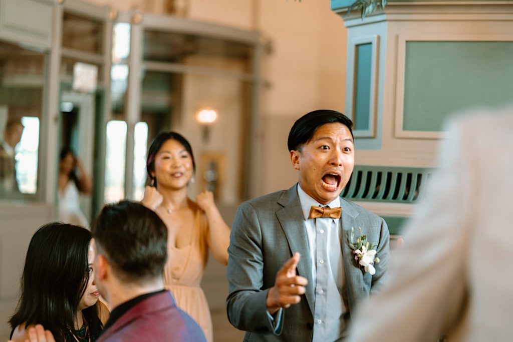 A groomsmen screams as he enters the reception at Joliet Union Station.