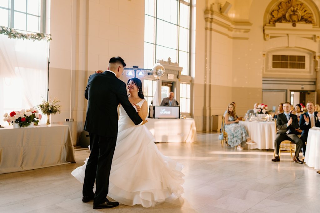 The bride and groom have their first dance at their wedding reception at Joliet Union Station celebrating with their guests.
