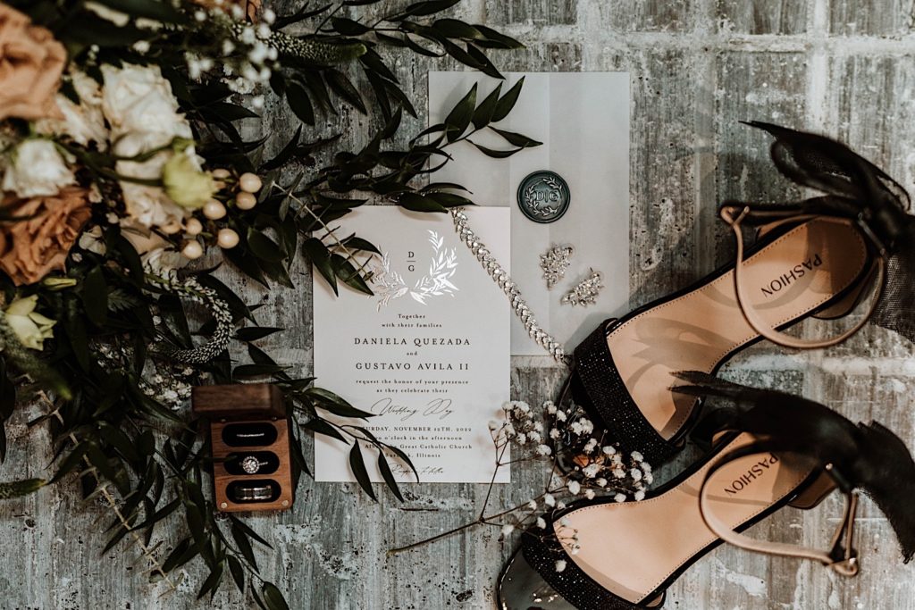 Wedding details with black wedding shoes and a wooden ring box with three spots for all three rings.