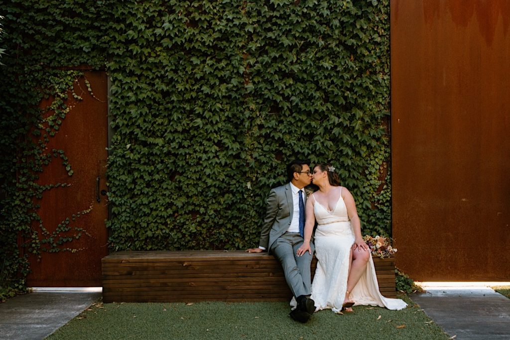 Newlyweds kiss and sit during portraits during their wedding day at the Lytle House